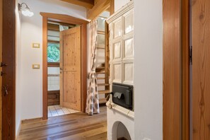 Ein rustikaler Innenraum mit Kamin, Holztür und Vorhang.