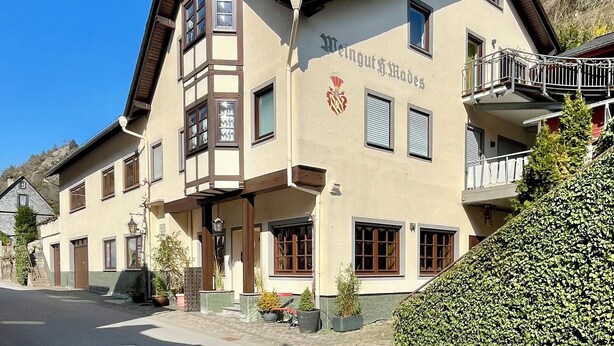 A traditional building with a prominent crest, multiple windows, and a balcony.