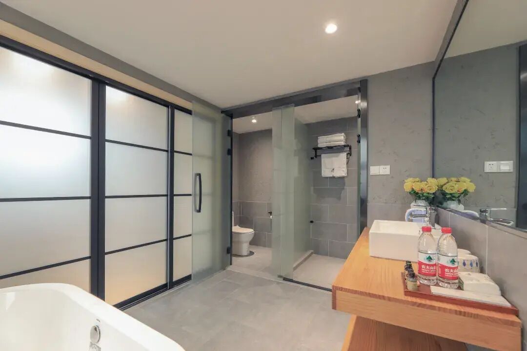 A modern bathroom with a bathtub, a toilet, and a shower area.