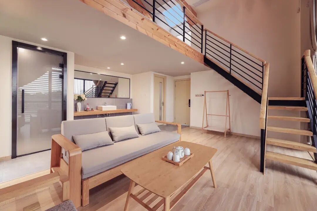Una sala de estar moderna con un sofá, una mesa de centro y una escalera.
