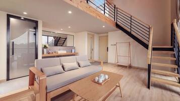 Una sala de estar moderna con un sofá, una mesa de centro y una escalera.