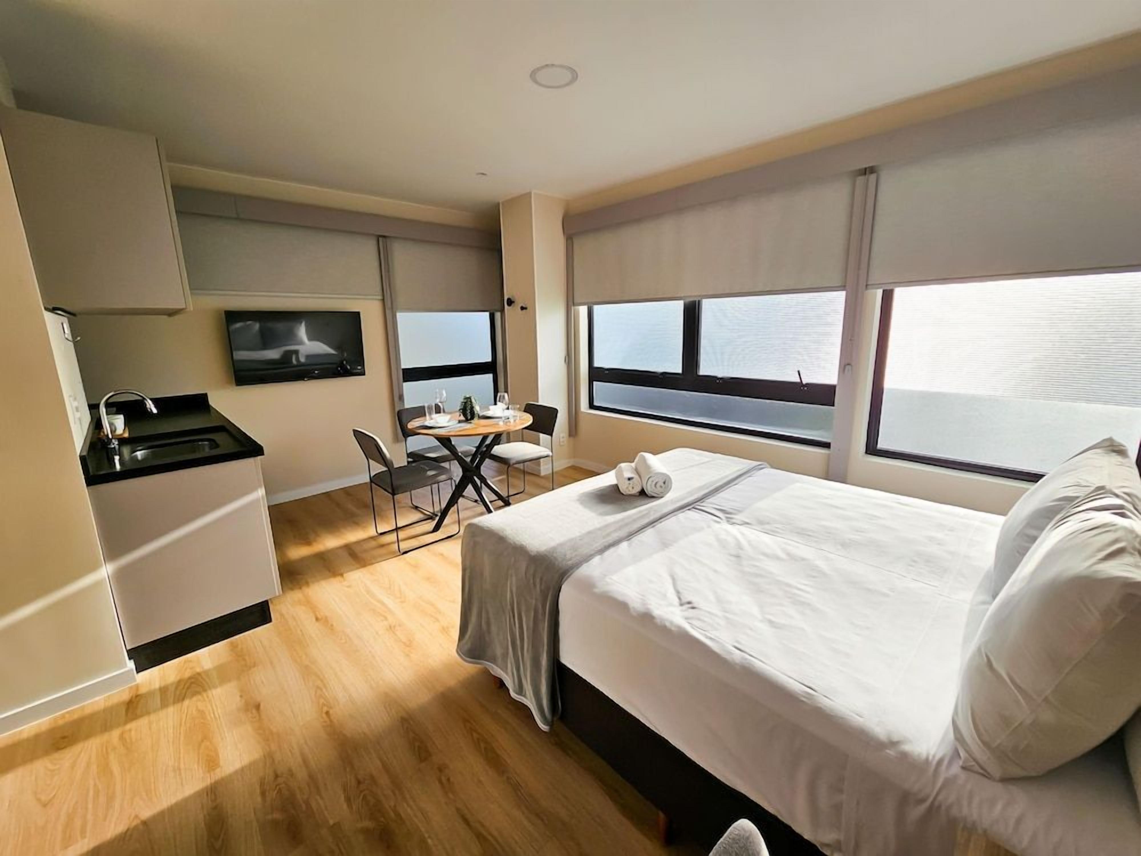 Une chambre d’hôtel équipée d’un lit, d’un bureau, d’une chaise, d’une télévision et d’une fenêtre donnant sur un paysage agréable.