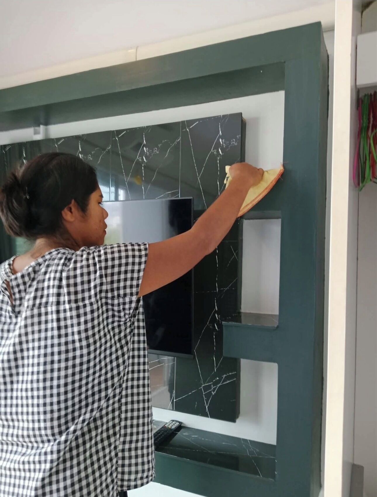 A person cleaning a wall with a sponge.