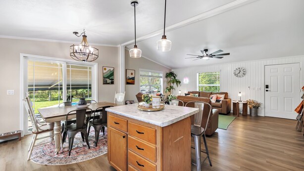 A spacious kitchen with a large island, wooden cabinets, and pendant lighting. - Brand new listing!!! Relax and unwind at this stunning Northwoods pool house featuring a private in-ground pool, fire pit, patio, garage space, and sleeping for 11 guests! (Mountain)