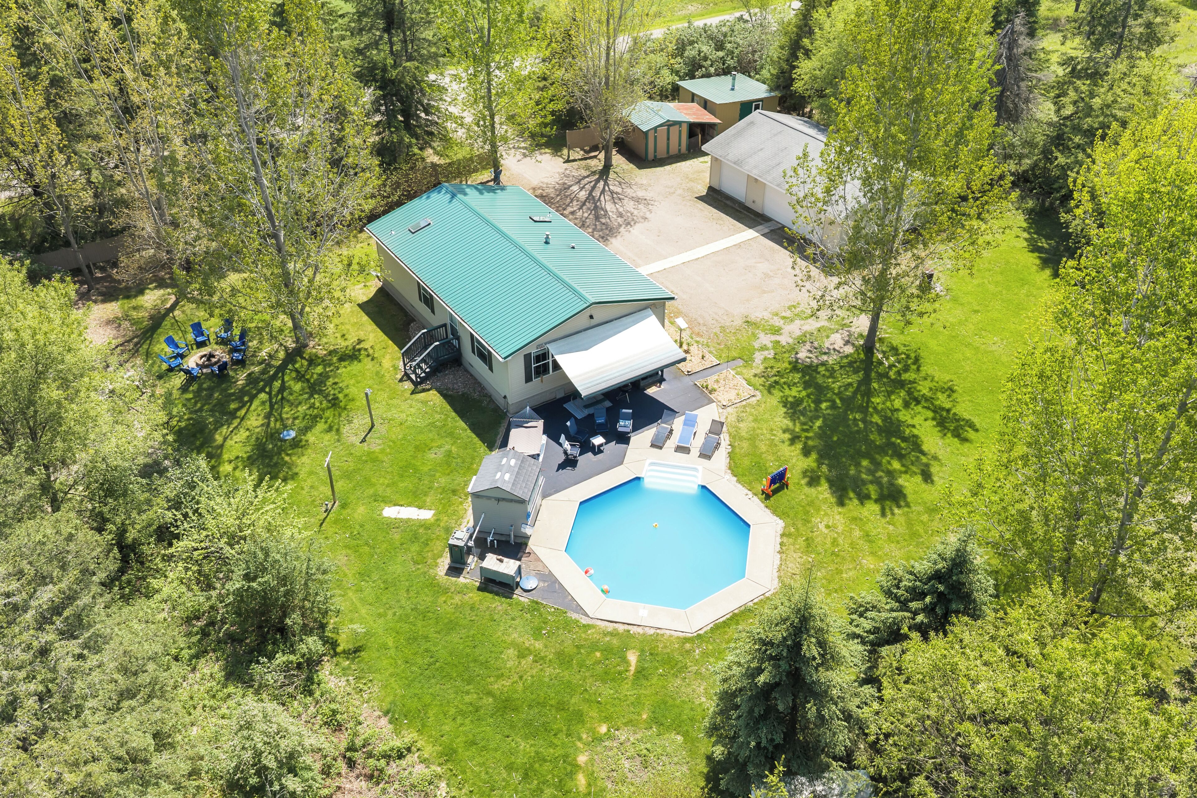 Vista aérea de una casa con piscina, un porche cubierto y un garaje.