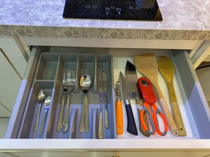 Eine Schublade mit verschiedenen Küchenutensilien und Werkzeugen.