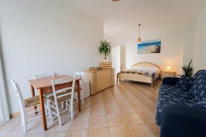 Ein Schlafzimmer mit Bett, Nachttisch, Lampe und einem Bild an der Wand.