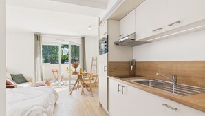 Una cocina moderna con armarios blancos, encimera de madera y pileta de acero inoxidable.
