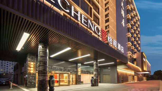 A hotel entrance with a prominent sign, a covered entrance area, and a tall building in the background. - Echeng Hotel Wuxi  Airport Branch (Wuxi)