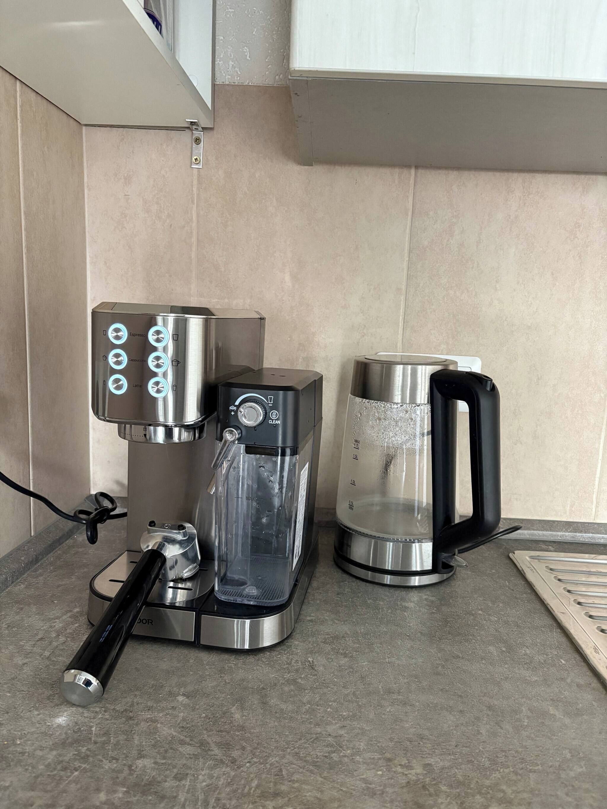A coffee maker, a water dispenser, and a coffee pot on a kitchen counter.