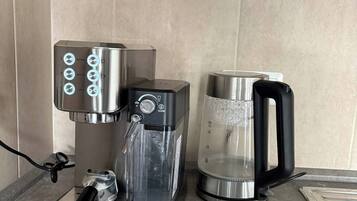 A coffee maker, a water dispenser, and a coffee pot on a kitchen counter.
