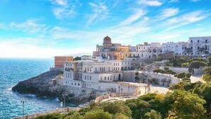 Un bâtiment situé sur la côte, doté de plusieurs étages, d’un dôme imposant et offrant une vue sur la mer.