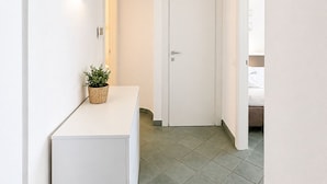 A hallway with a white reception desk, a door, and a potted plant. - Vacation home facing the sea in Scylla (Scilla)