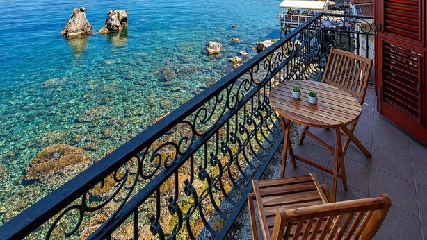 A balcony with a clear view of the sea, a wooden table, and chairs. - Vacation home facing the sea in Scylla (Scilla)