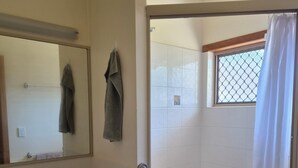 Een badkamer met een bad, een wastafel, een spiegel en een douchegordijn.