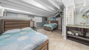 Una camera da letto con due letti, una toeletta con specchio e una televisione.