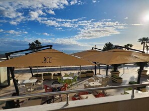 Habitación triple Deluxe, balcón, vista al mar | Restaurante al aire libre