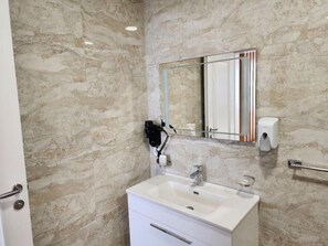 Suite Deluxe, balcón, vista al mar | Baño | Regadera, amenidades de baño gratuitas, secadora de cabello, pantuflas 