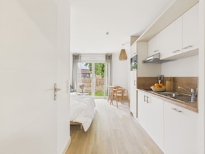 A modern kitchen with white cabinets, a wooden countertop, and a sink. - Backdoor - studio for 3 - shared pool (Biscarrosse)