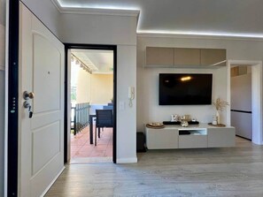 Ein modernes Wohnzimmer mit Flachbildfernseher, einem weißen Unterhaltungsschrank und Holzboden.