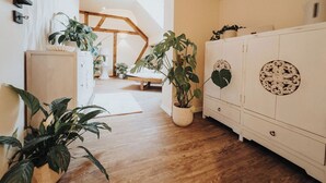 A hallway with wooden flooring, white walls, and a white cabinet with decorative panels. - High-quality vacation apartment with sauna and fitness (Tholey)