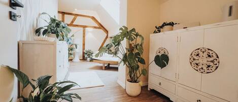 Un pasillo con suelo de madera, paredes blancas y un armario blanco con paneles decorativos.