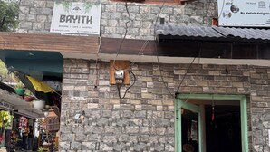 Un edificio con letreros que indican 'Bayith Cafe' y 'Geeta Guest House', señalando que ofrece habitaciones, cafetería y servicios de hostal.