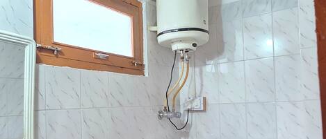 Un baño con lavamanos blanco, inodoro y ventana.