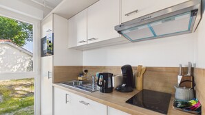 Una cocina moderna con estufa integrada, cafetera y tostadora.