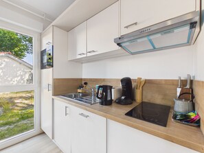 A modern kitchen with a built-in stove, a coffee maker, and a toaster. - Uluwatu – studio for 2 – shared pool (Biscarrosse)