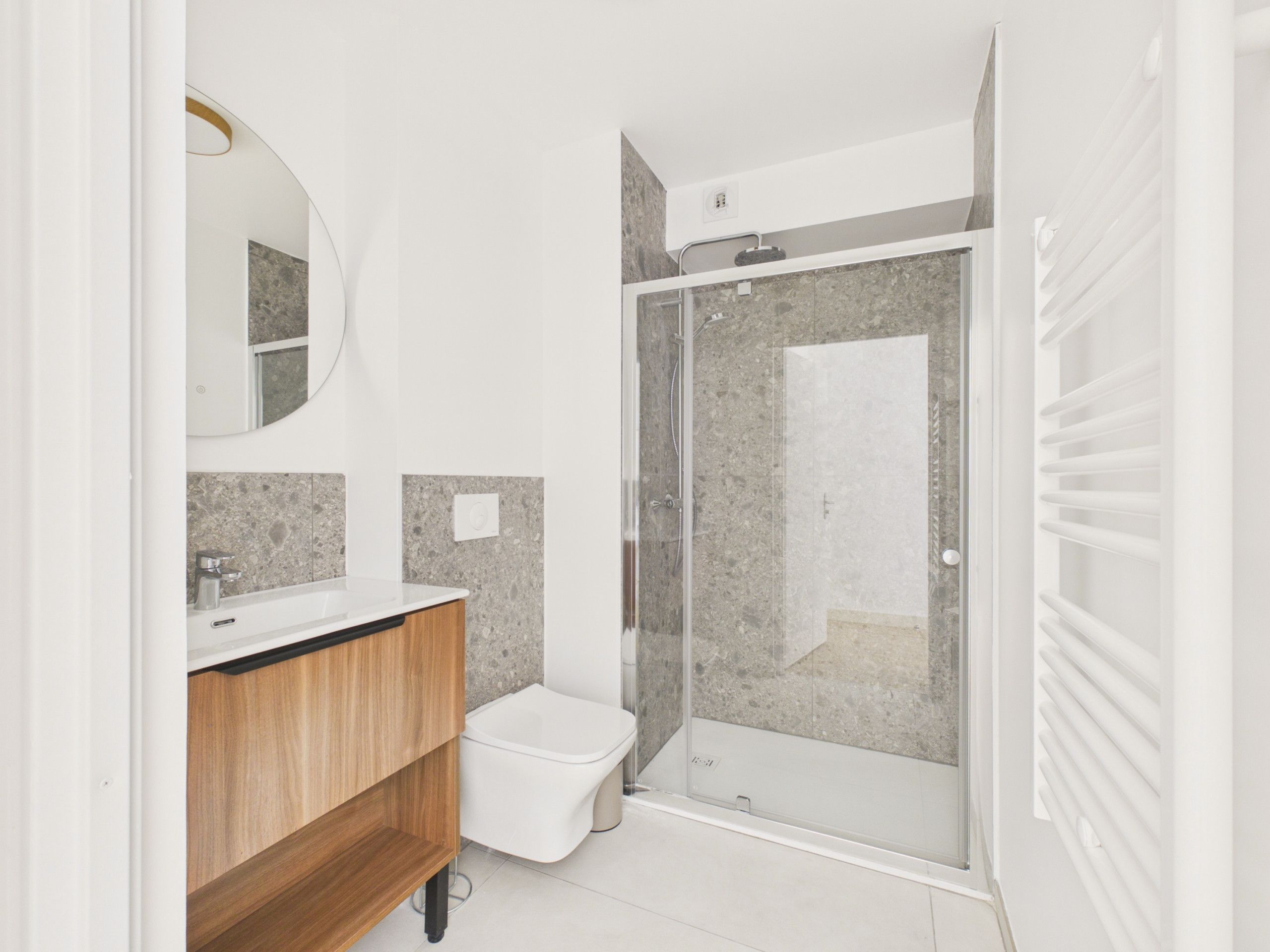 A modern bathroom with a shower, toilet, and vanity.