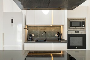 Eine moderne Küche mit einem Kühlschrank, einer Spüle, einer Kaffeemaschine, einer Mikrowelle und einem Backofen – alles von Bosch.