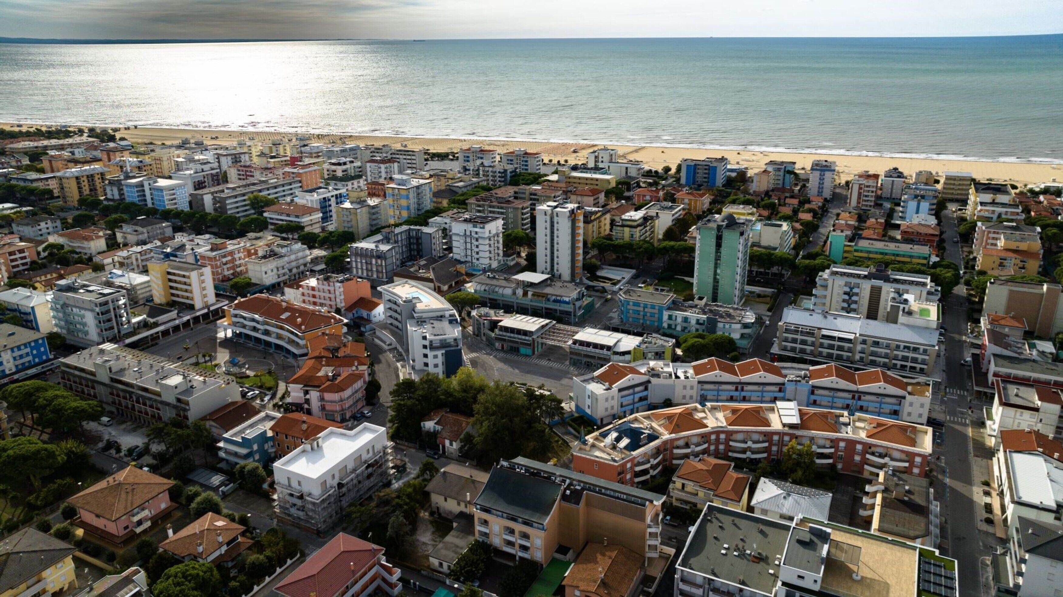 Vue aérienne d’une ville côtière, avec une plage en arrière-plan.