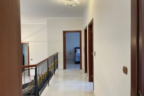 Ein Flur mit einer Treppe, die zu einem Schlafzimmer führt.