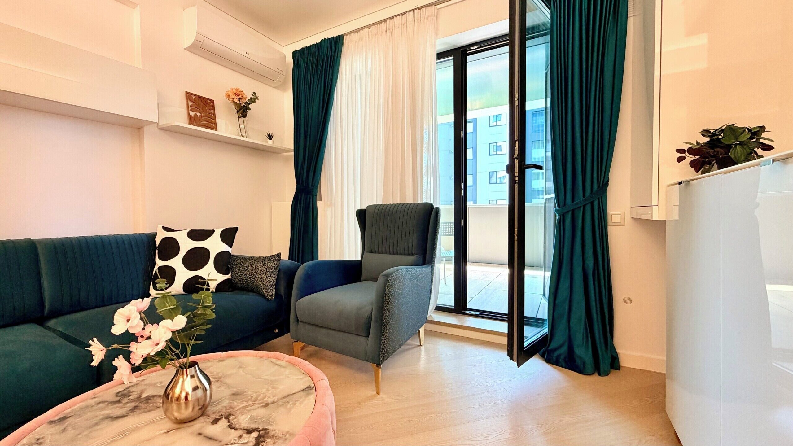 Una sala de estar con un sofá, un sillón y una mesa de centro con un florero.