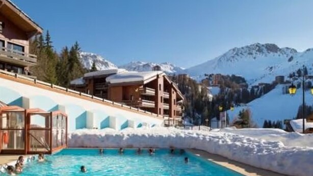 A pool area with people swimming, surrounded by buildings and snow-covered mountains. - Beautiful 2-room apartment for 4 people, balcony, Plagne 1800 (La Plagne 1800)