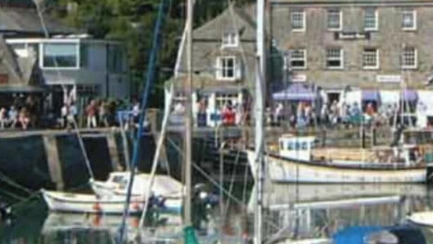 A harbor with several boats docked, including one with 'ASTRAMARE' written on it.