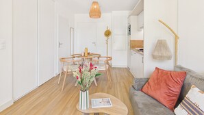 Un soggiorno moderno con angolo ristoro, angolo cottura e divano con cuscino decorativo.
