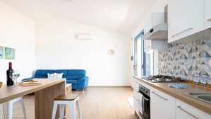 Una cucina moderna con un piano di lavoro in legno, pensili bianchi, un divano blu e un rivestimento a mosaico.