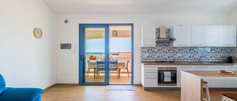 Un apartamento moderno con sala de estar, cocina y balcón.
