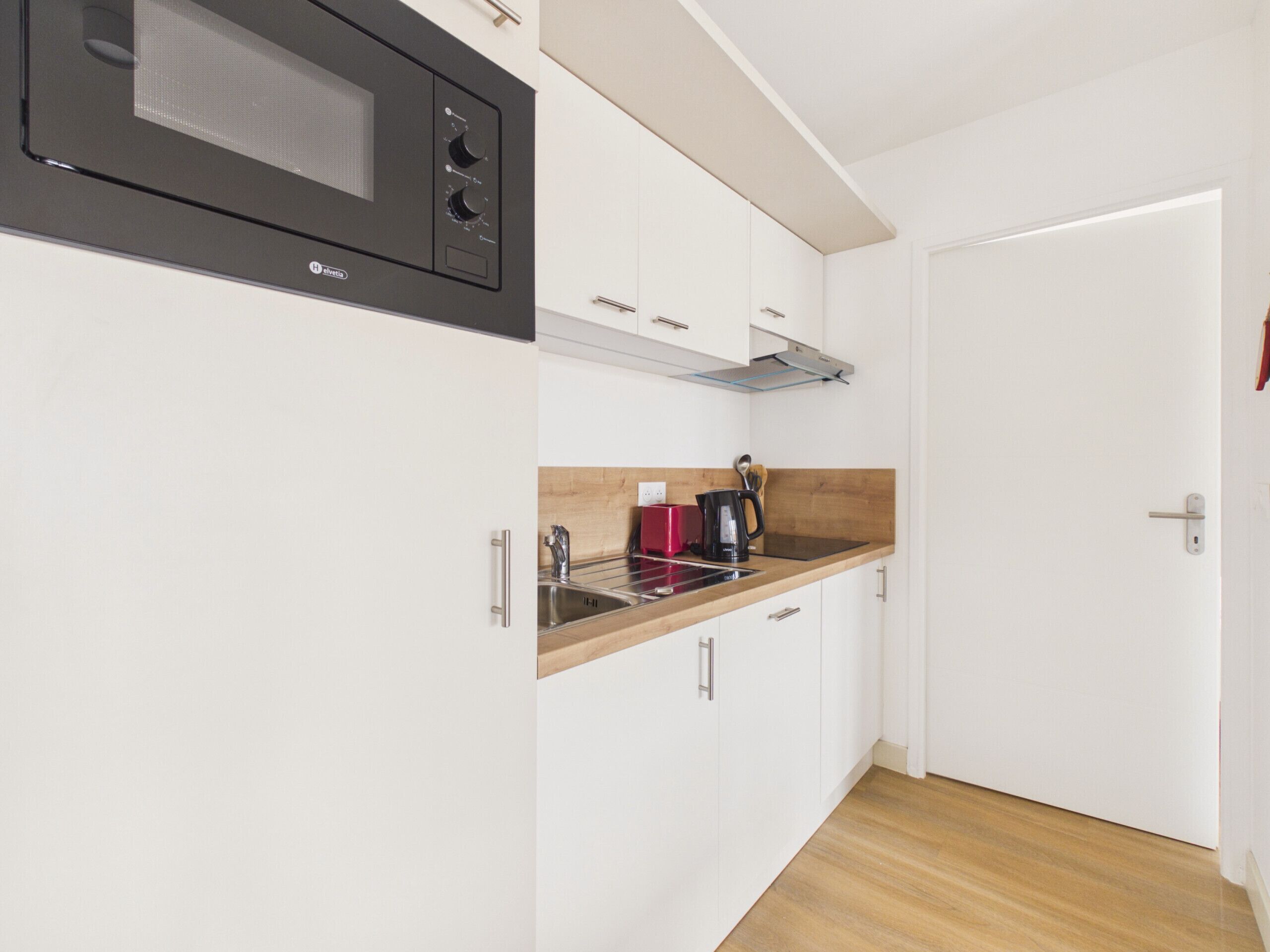 A compact kitchen with a microwave, toaster, and coffee maker.