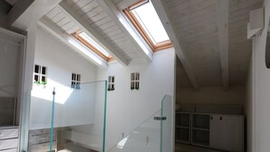 A modern interior with skylights, a glass railing, and a staircase. - Torrette "The First" - Pool-front relax within walking distance of everything (Peschiera del Garda)