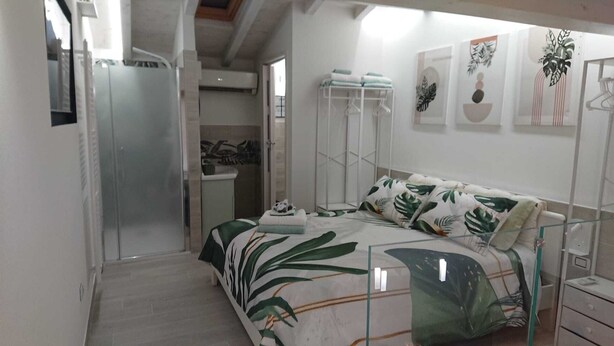 A bedroom with a bed, a wardrobe, a shower, and a bathroom. - Torrette "The First" - Pool-front relax within walking distance of everything (Peschiera del Garda)