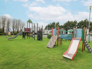 A playground with slides and climbing structures. - The Dorchester at Bay View (New Quay)