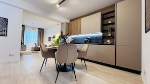 Une cuisine moderne avec un coin repas, des meubles en bois et un four encastré.