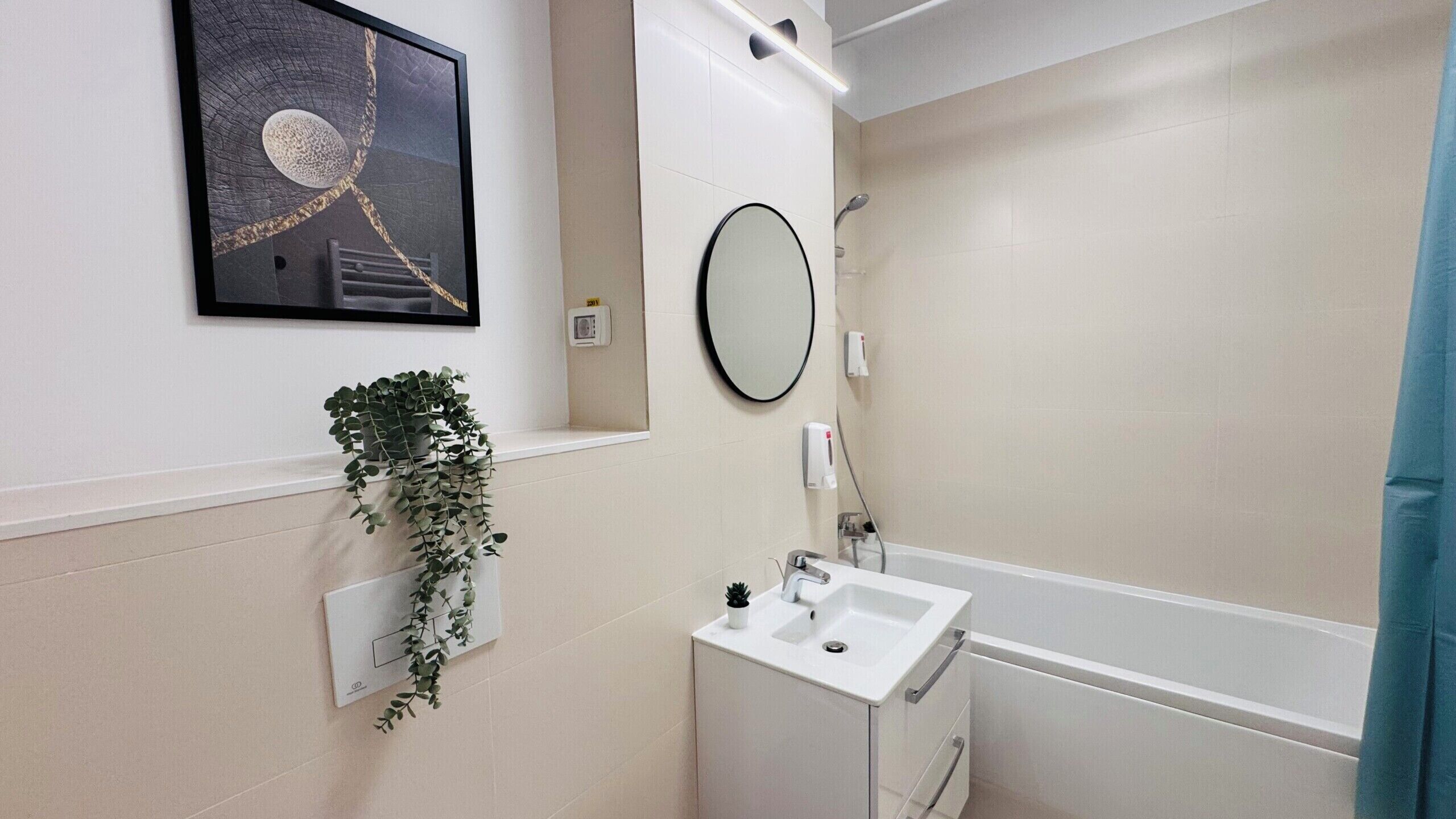 Un baño con lavamanos, espejo y ducha.