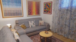 A living room with a grey sofa, a round wooden coffee table, and a patterned rug. - 10 minutes from Lucca, 130 sq. m. apartment with garden, pets dom. allowed (Capannori)