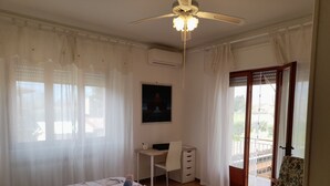 A bedroom with a bed, a desk, a chair, a ceiling fan, and a balcony. - 10 minutes from Lucca, 130 sq. m. apartment with garden, pets dom. allowed (Capannori)