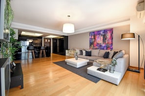 A modern living room with a sofa, coffee table, and a painting on the wall. - Great Apartments in Prime North Location (Bucharest)