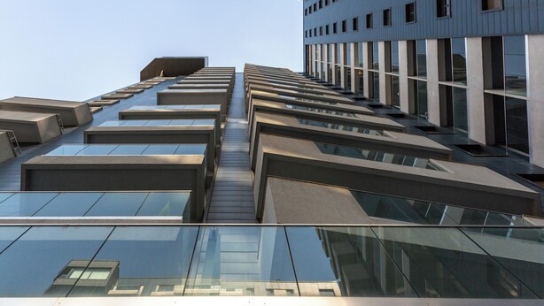 A modern building with a glass facade and a series of balconies. - Great Apartments in Prime North Location (Bucharest)